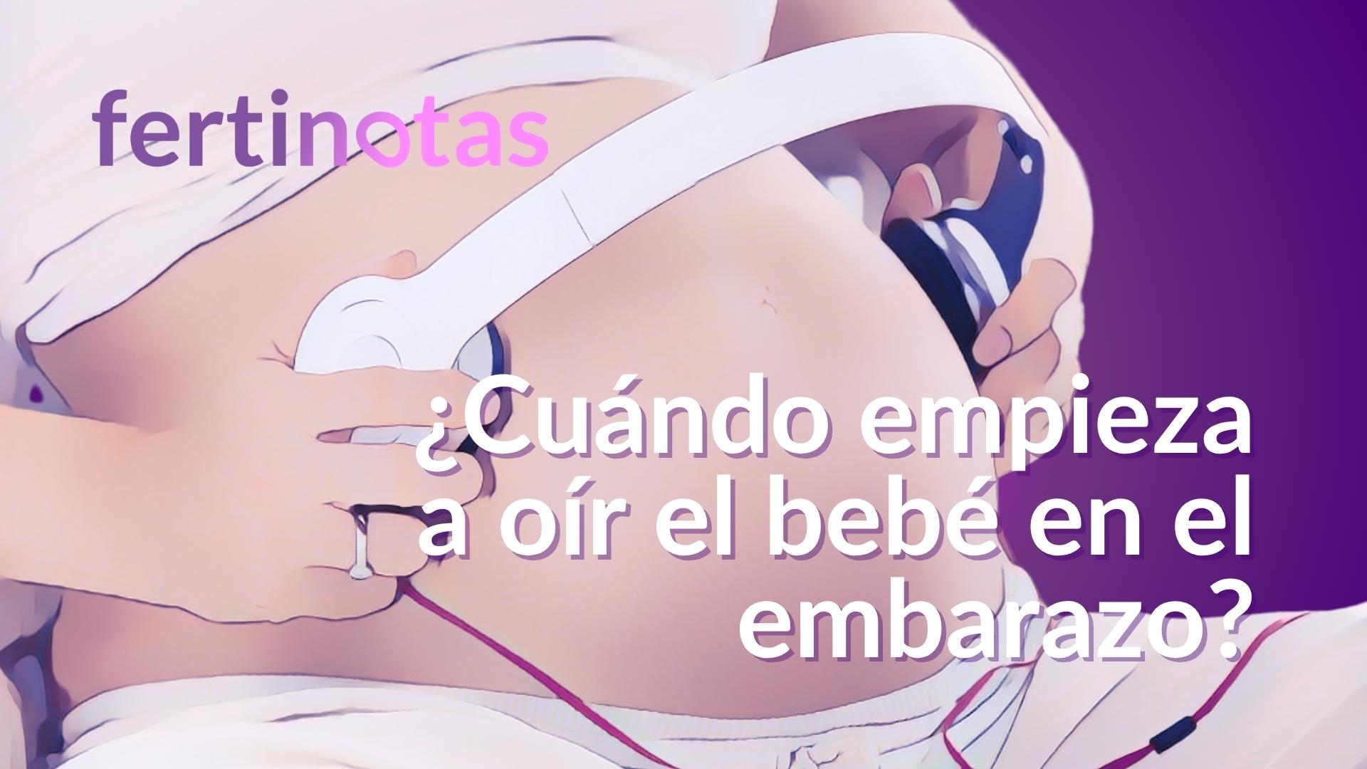 cuando comienza a oir el bebe en el embarazo Mujer embarazada colocando auriculares en su vientre para estimular el oído del bebé.