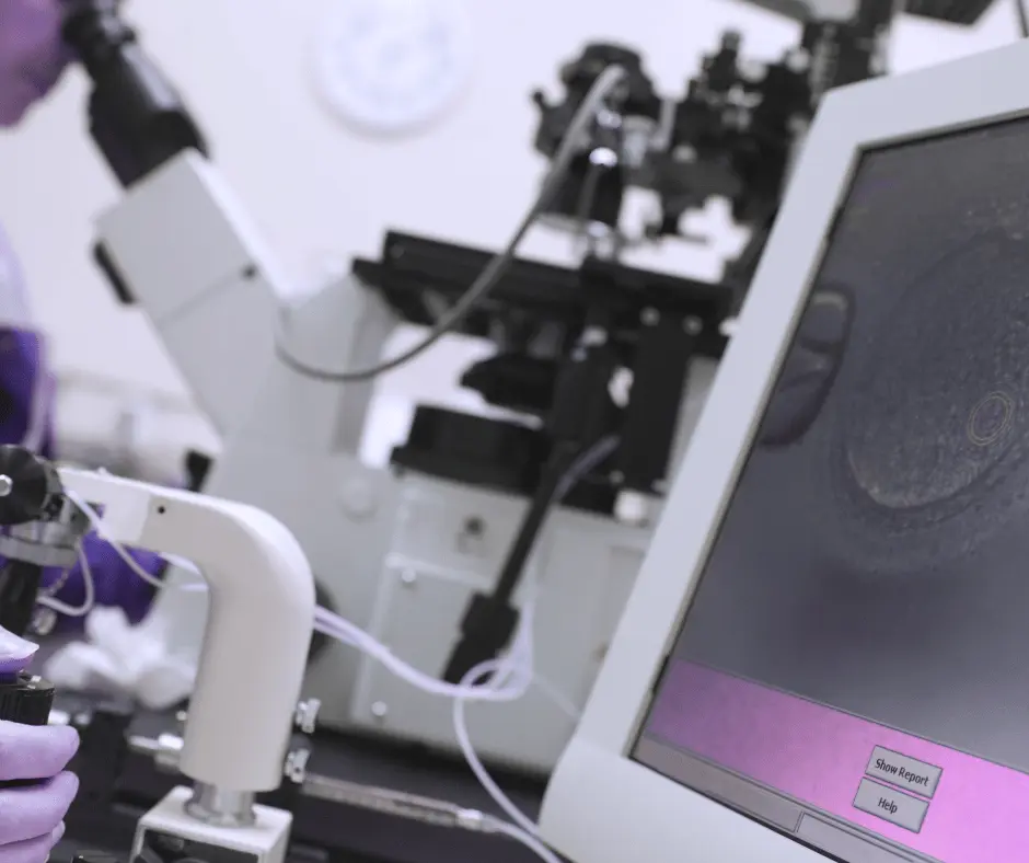 Equipo de laboratorio observando un ovocito durante un procedimiento de fecundación in vitro con ICSI
