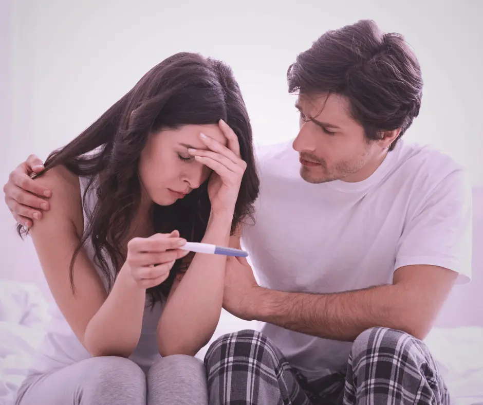 Pareja afrontando un resultado negativo en una prueba de embarazo durante un tratamiento de reproducción asistida